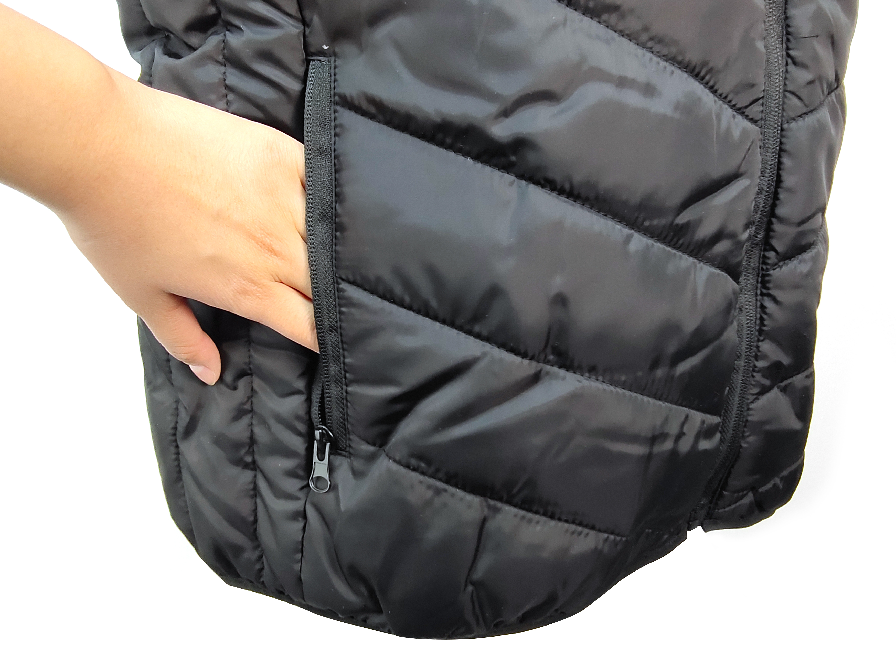 Close-up of a hand reaching into the zippered side pocket of the Hilipert heated vest